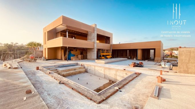 Edificio en construcción con piscina vacía y paisaje despejado al fondo.